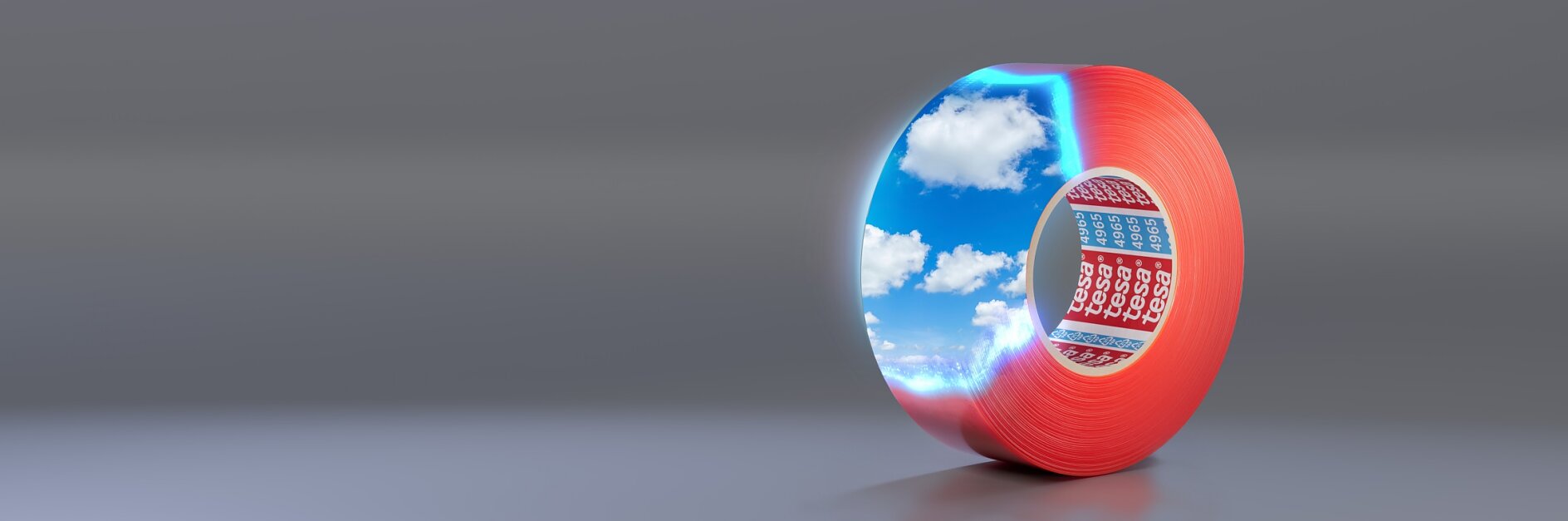 A roll of red tesa tape with reflective coating, showing a vivid sky with clouds on its surface. It is positioned upright on a smooth, gray background. (This text has been generated by AI)